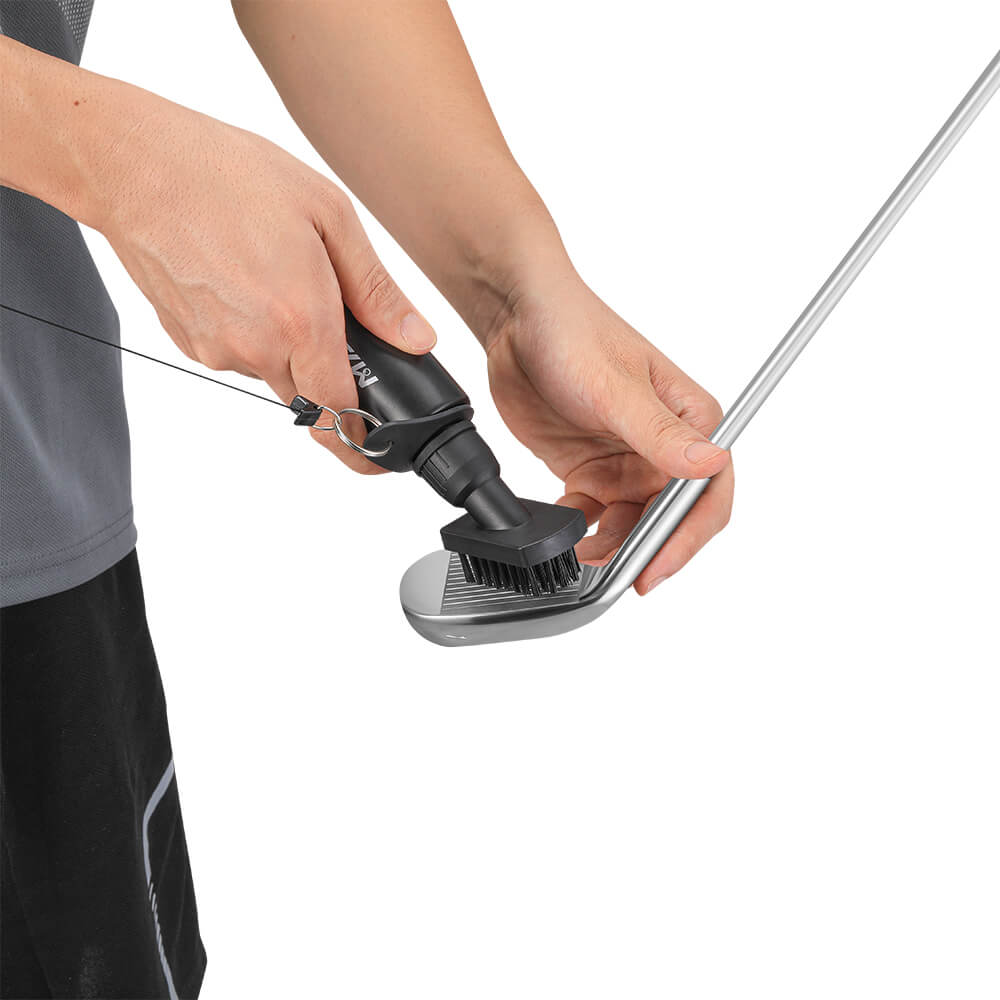 Close-up of golf club head being cleaned with soft brush for better performance